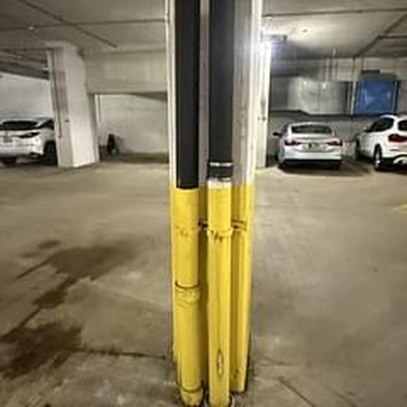 Cast iron drain pipes with yellow protective guards in garage