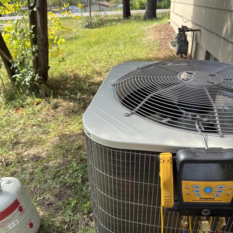 Central AC unit with diagnostic gauges in yard Central AC unit with diagnostic gauges in yard
