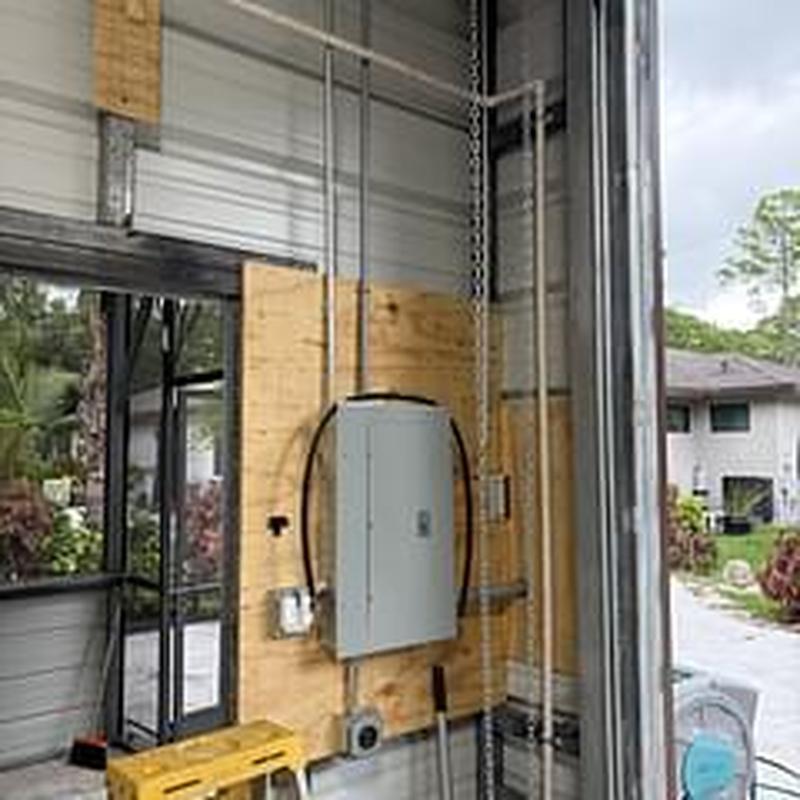 Electrical panel with conduit installation in garage wall