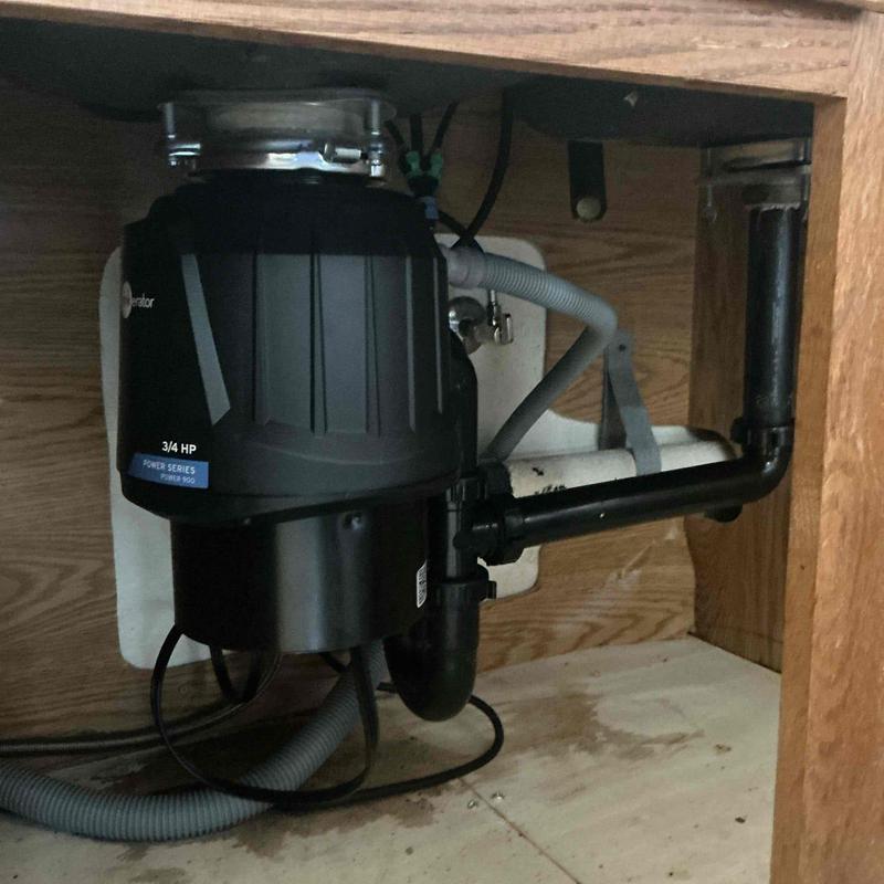Garbage disposal under sink with drain pipes installed Garbage disposal under sink with drain pipes installed