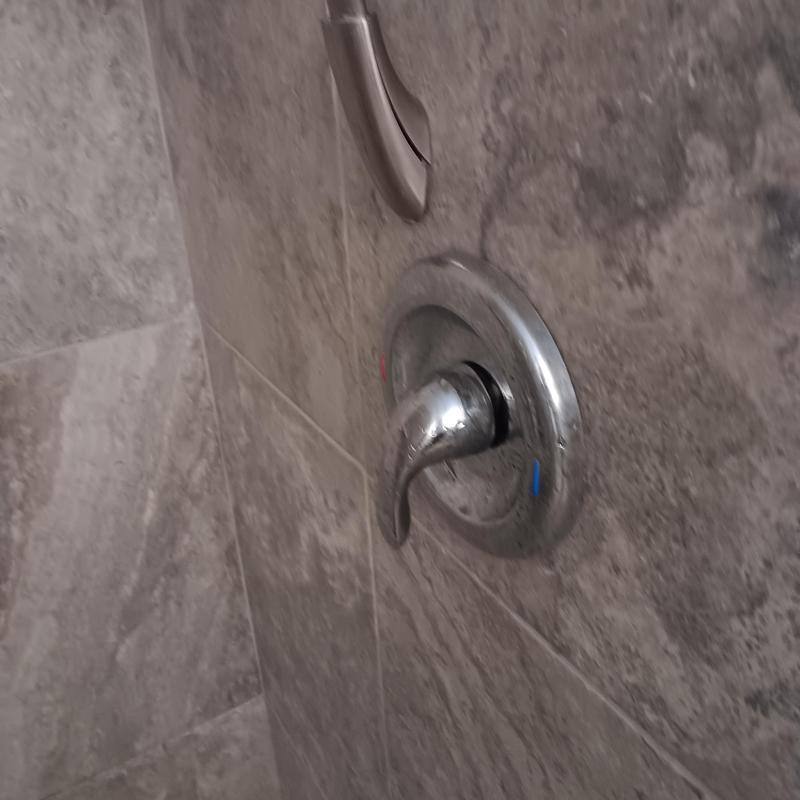 Shower valve handle and trim on tiled wall Shower valve handle and trim on tiled wall