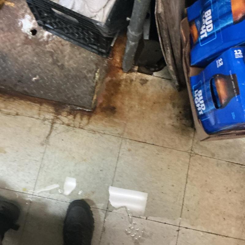 Commercial drain behind soda machine with rust stains