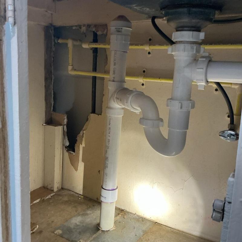 PVC drain pipes under kitchen sink installed and secured