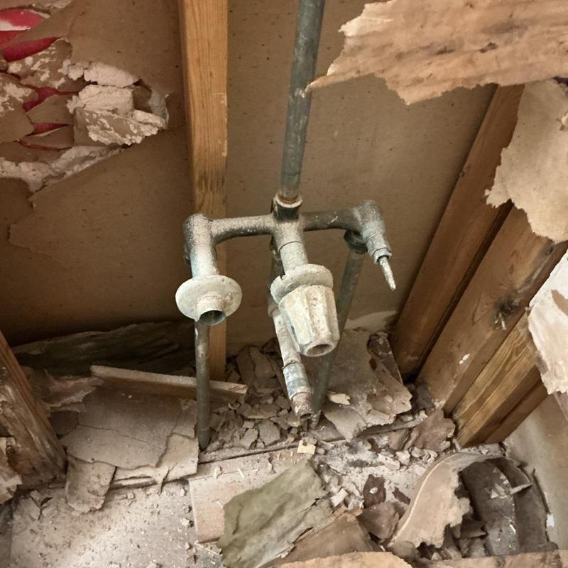 Galvanized supply pipes with faucet valves in wall cavity