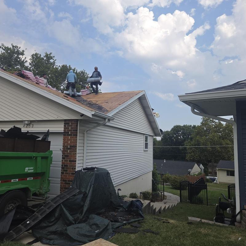 Roof plywood installation with crew on steep roof