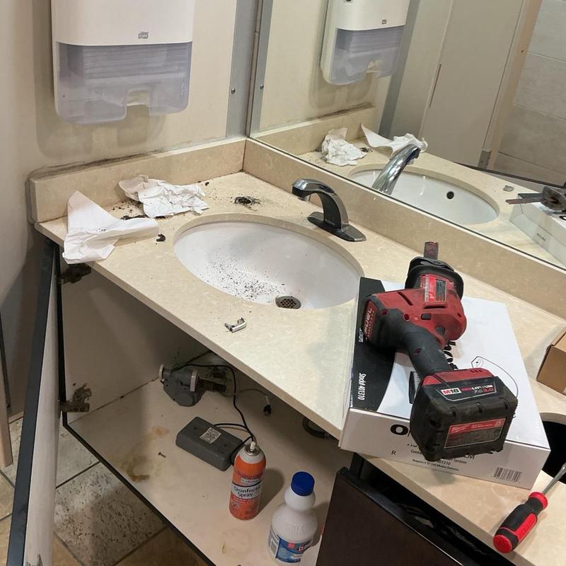 Soap dispensers replacement tools on restroom sink counter