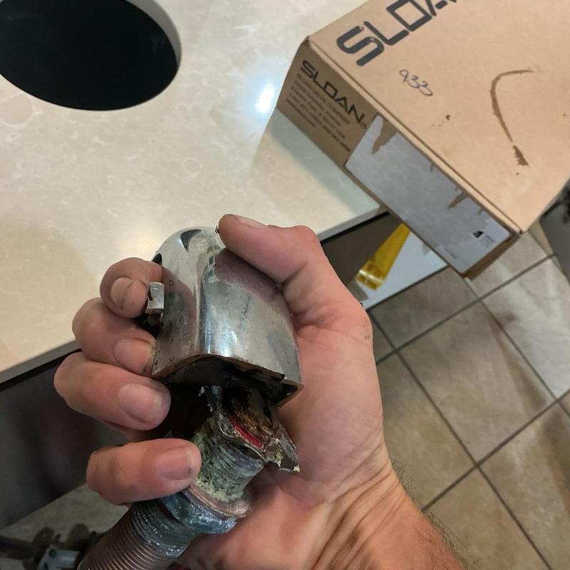 Sloan sensor-operated soap dispenser held by hand
