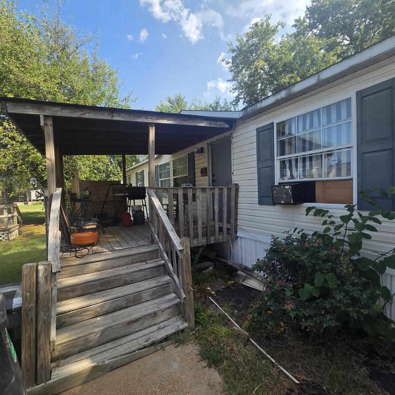 Roof damaged by fallen tree with porch stairs