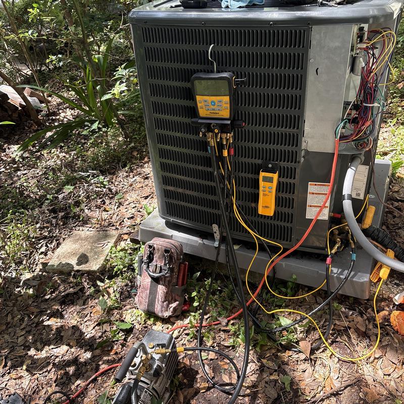 Air conditioning unit with vacuum pump and gauges in use Air conditioning unit with vacuum pump and gauges in use