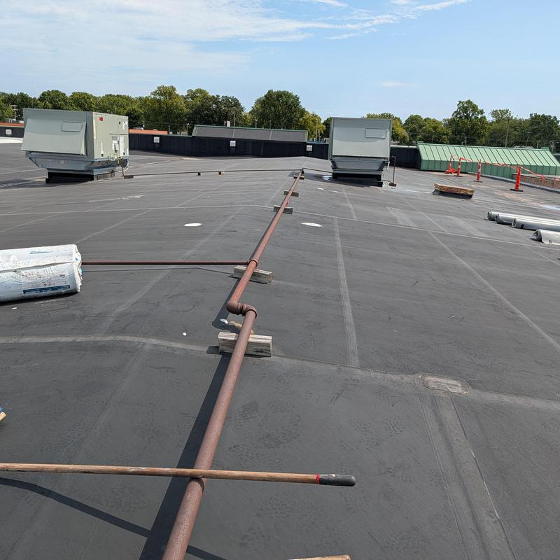 Flat EPDM rubber roof with metal pipe and HVAC units