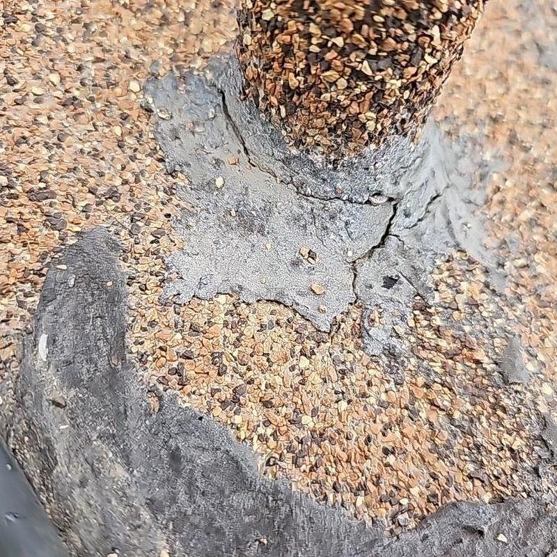 Pipe flashing on flat roof with visible damage