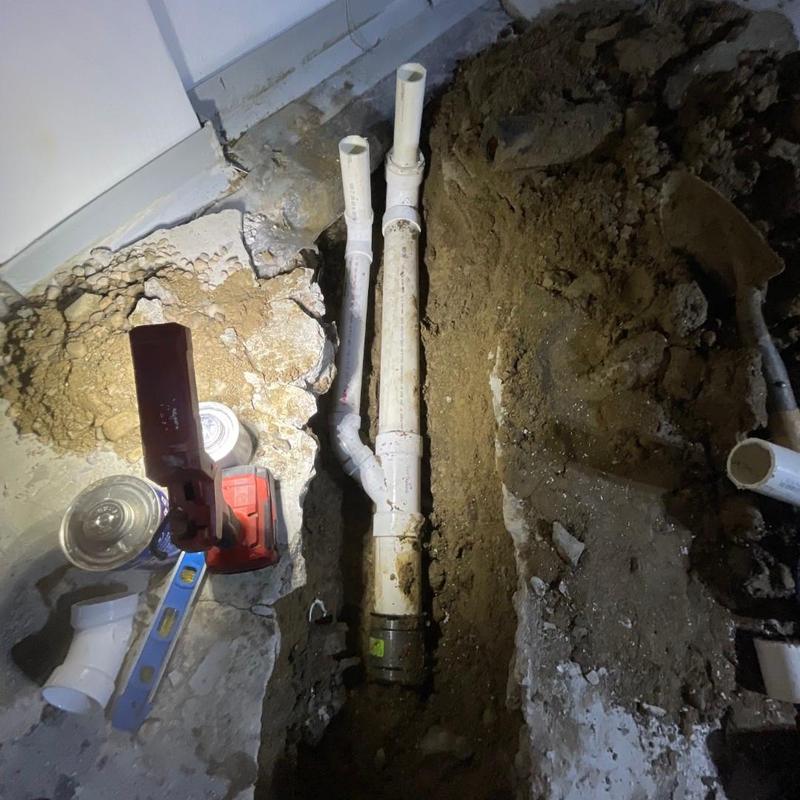 PVC laundry and kitchen drain installation in concrete floor