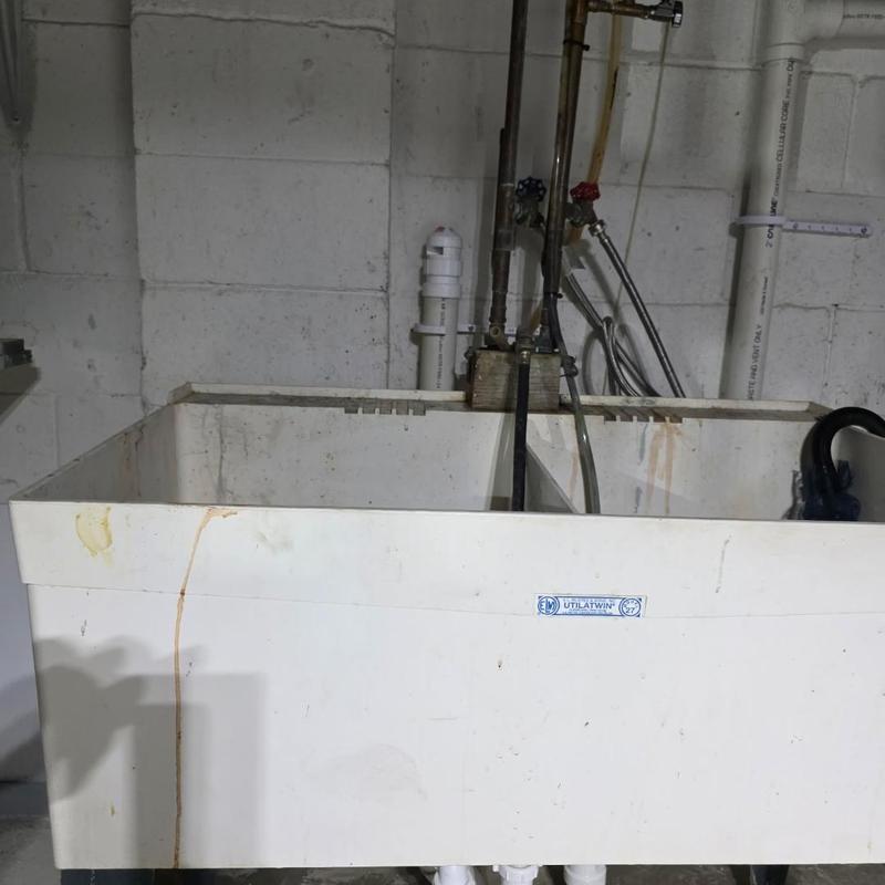 Laundry and kitchen drain installation behind utility sink