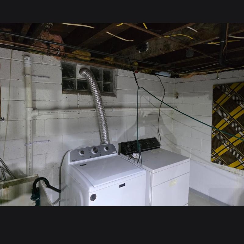 Laundry drain installation in basement with washer and dryer
