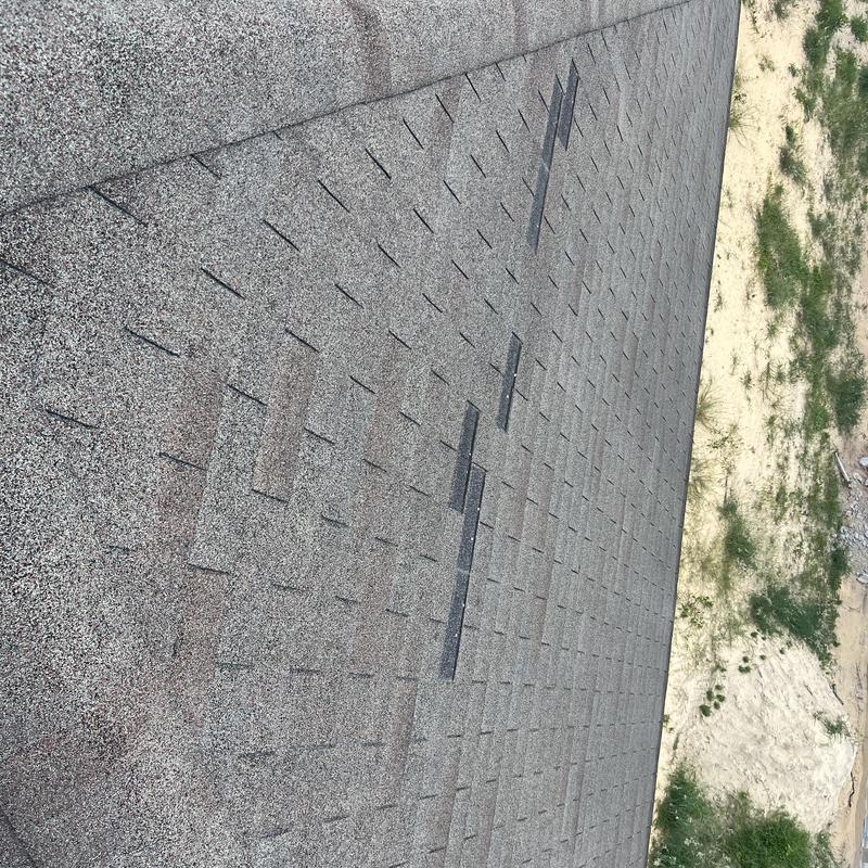 Shingle roof with patch repairs and weathering signs Shingle roof with patch repairs and weathering signs