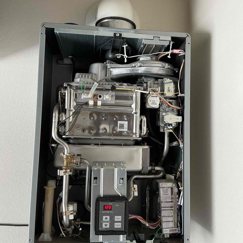 Tankless water heater interior with control panel and pipes Tankless water heater interior with control panel and pipes