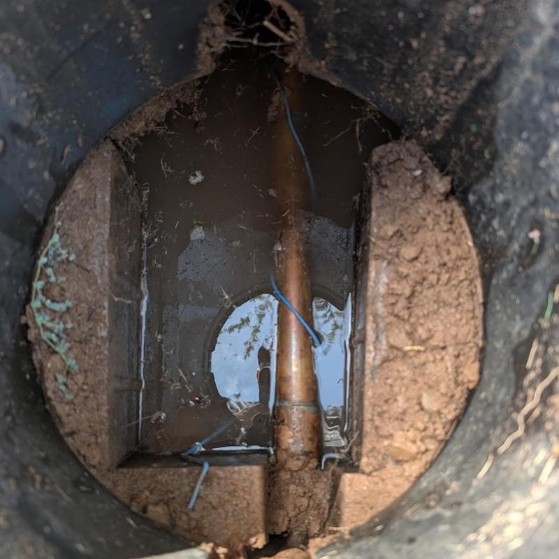 Water service pipe in meter pit with muddy water