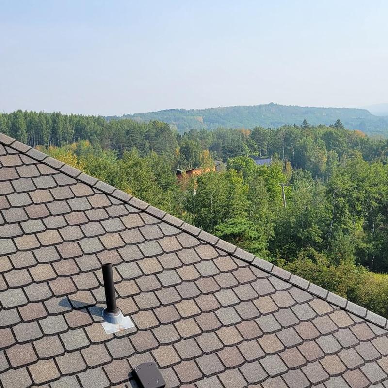 Asphalt shingle roof with vent pipe and forest view Asphalt shingle roof with vent pipe and forest view