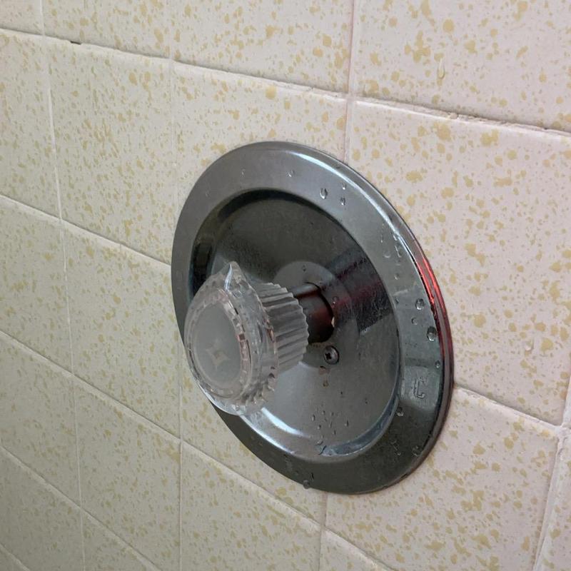 Shower valve with clear plastic handle on tiled wall Shower valve with clear plastic handle on tiled wall