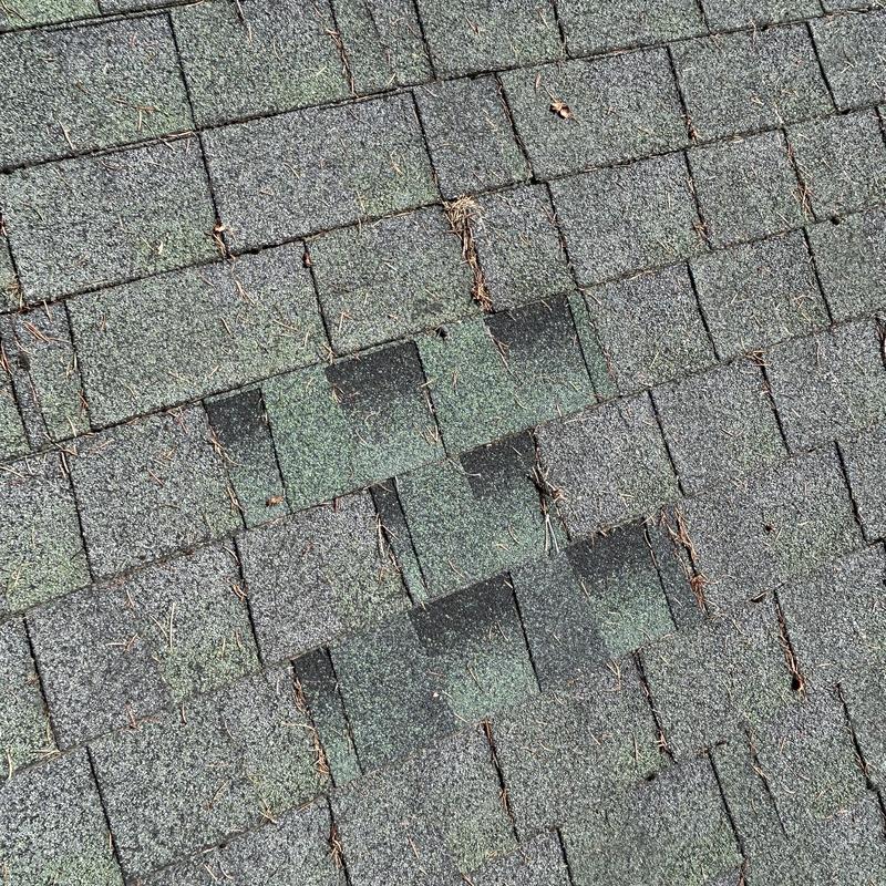 Asphalt roof shingles showing wear and algae growth