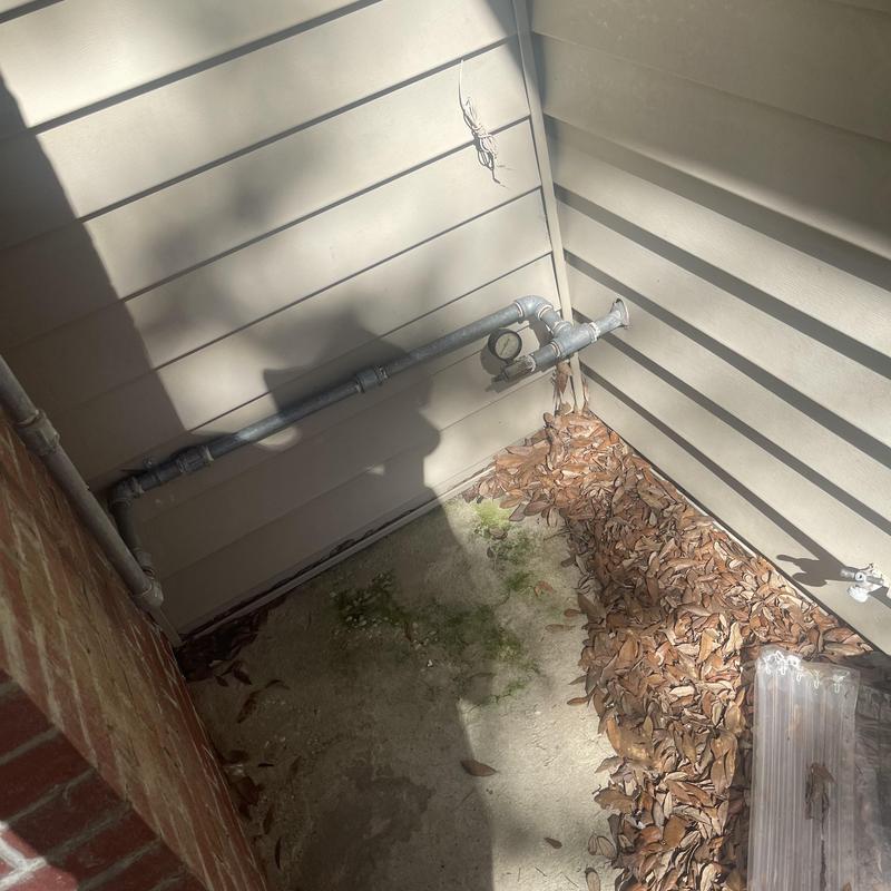 Gas meter piping with pressure gauge on house exterior Gas meter piping with pressure gauge on house exterior