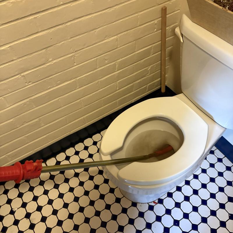 Toilet main line auger cleaning on hex tile floor Toilet main line auger cleaning on hex tile floor
