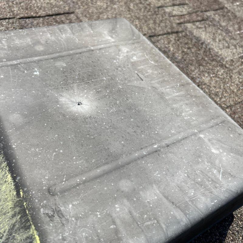 Roof vent cover with hail damage impact mark