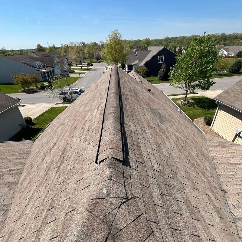 Asphalt roof shingles with hail damage on ridge line