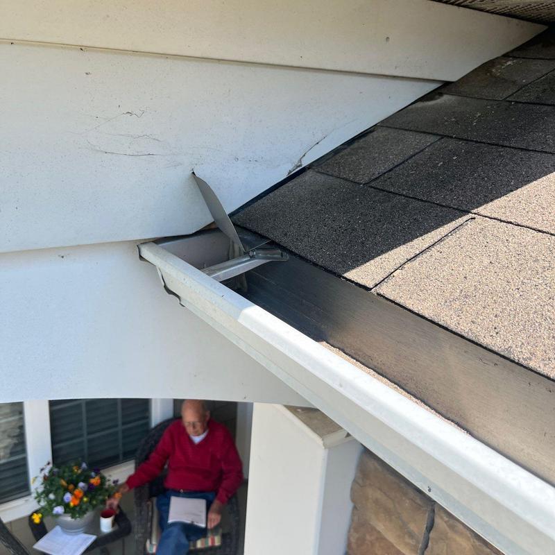 Roof shingles near damaged gutter and fascia board