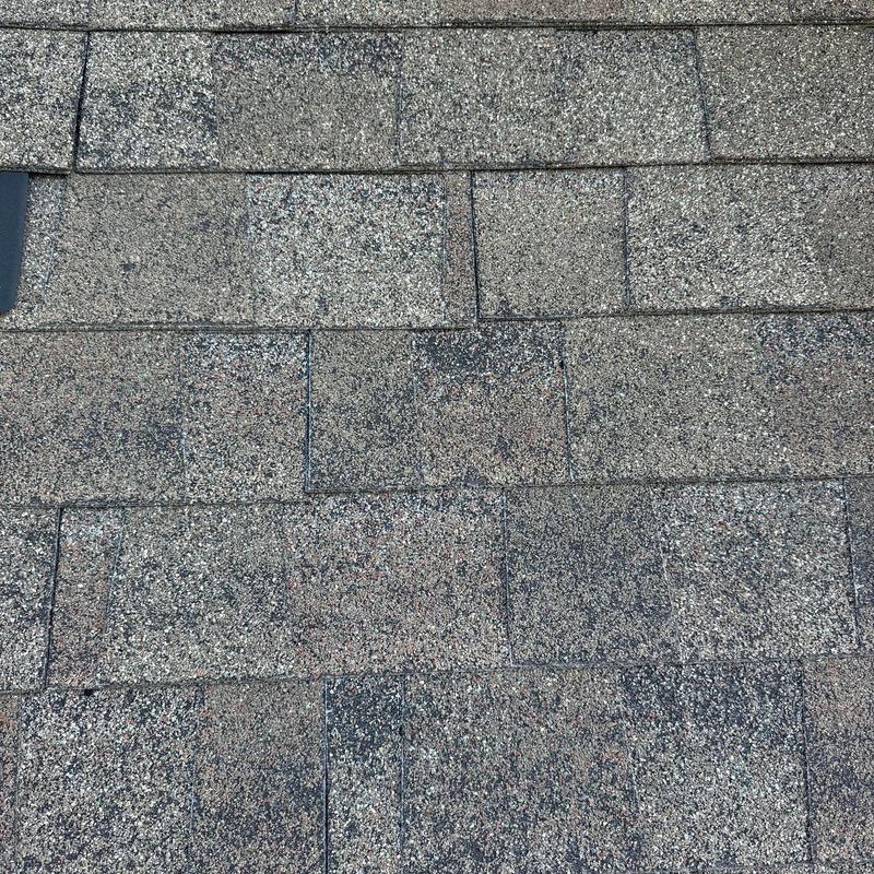 Asphalt roof shingles with hail damage visible