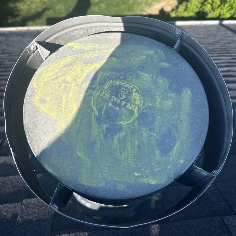 Roof vent cap with yellow inspection markings on roof