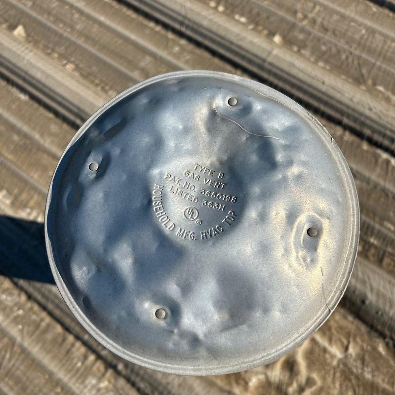 Gas vent cap with dented metal on roof