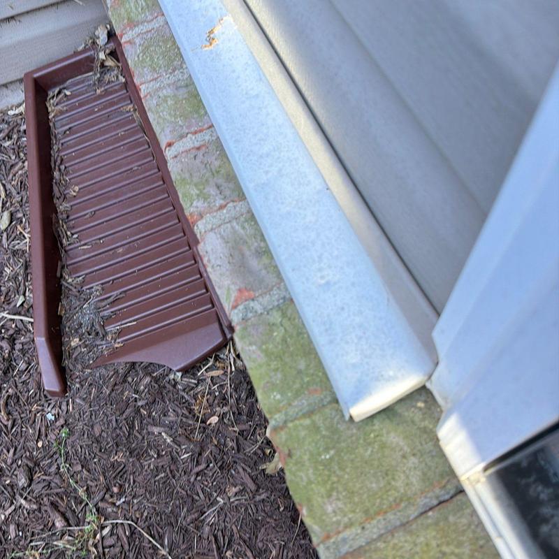 Window well cover cracked and displaced near foundation bricks