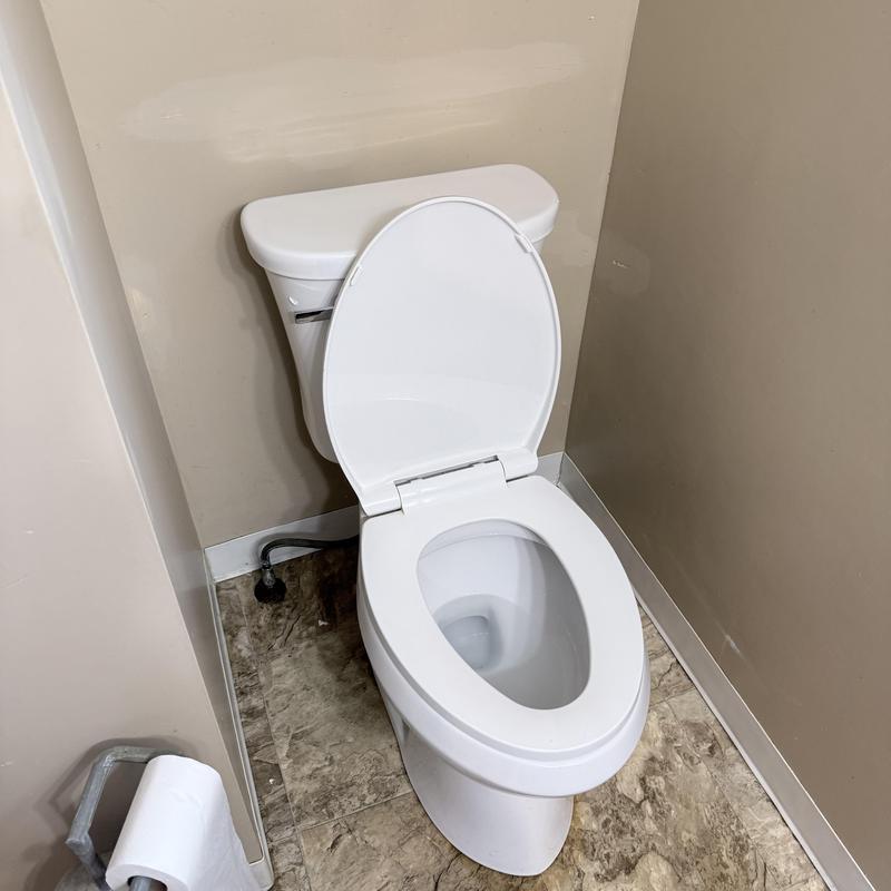 Smart toilet with open lid in small bathroom corner Smart toilet with open lid in small bathroom corner
