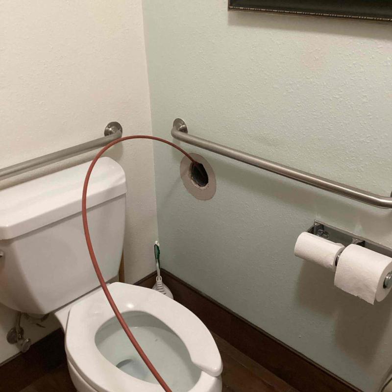 Toilet drain pipe hydro jetting cleaning in bathroom