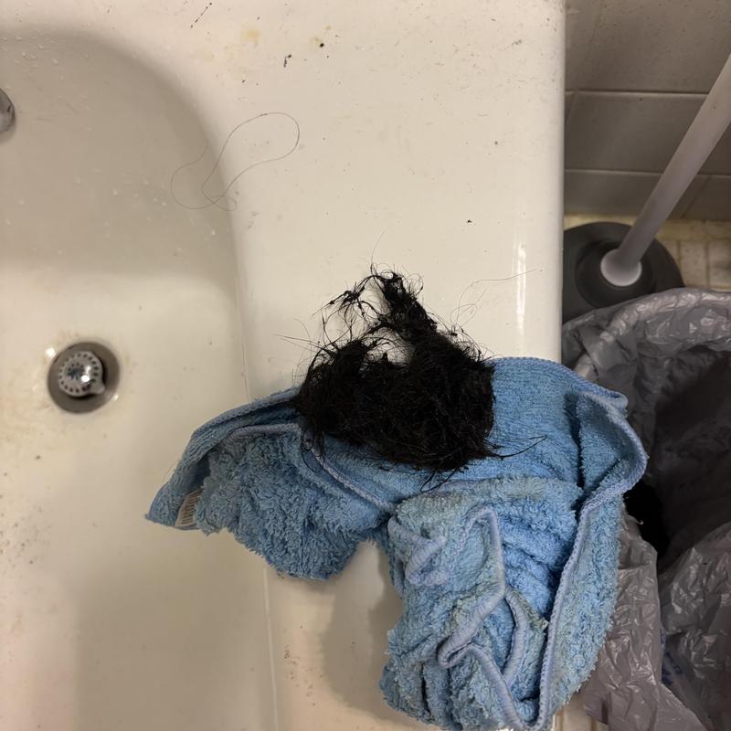 Bathtub drain clog with removed hair and towel Bathtub drain clog with removed hair and towel