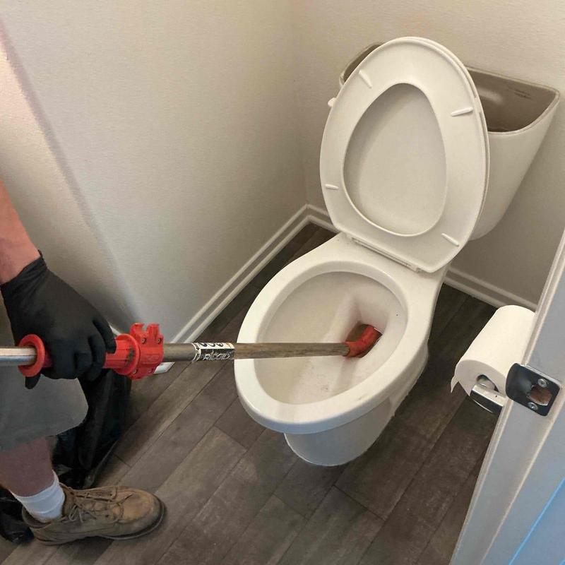 Toilet auger clearing blockage and restoring drainage
