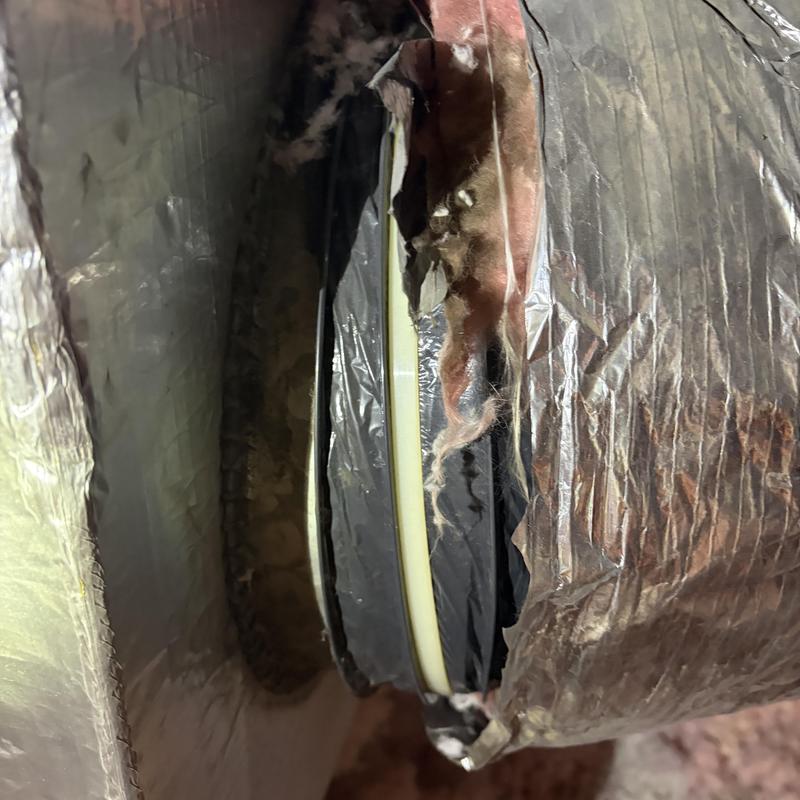 Duct insulation with torn vapor barrier in attic space