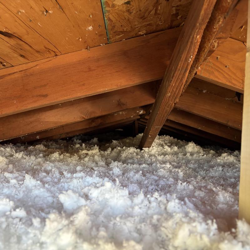 Attic insulation installation with wooden roof beams Attic insulation installation with wooden roof beams
