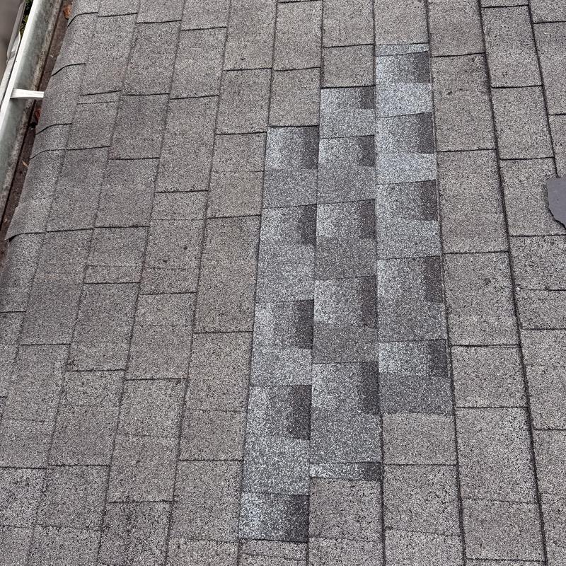 Asphalt roof shingles with patched repair section