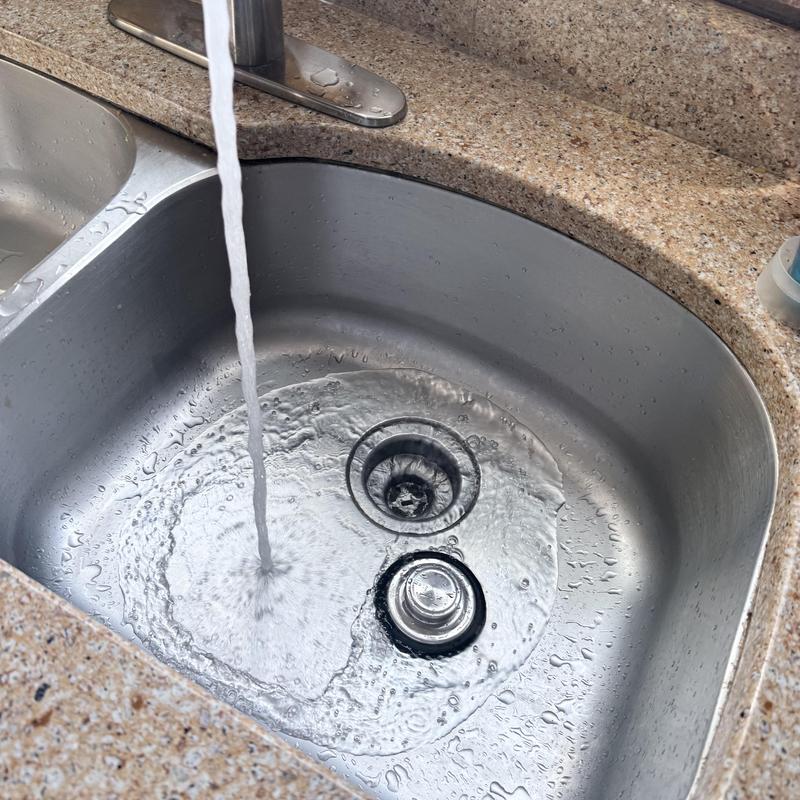 Kitchen sink drain clearing with running water Kitchen sink drain clearing with running water