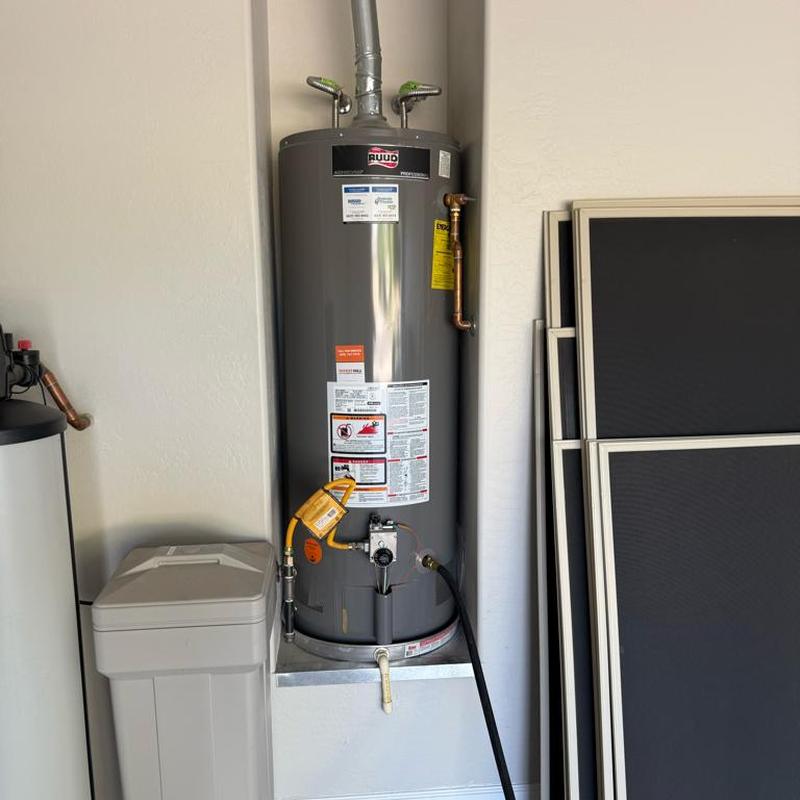 Water heater flushing with connected hose in utility room