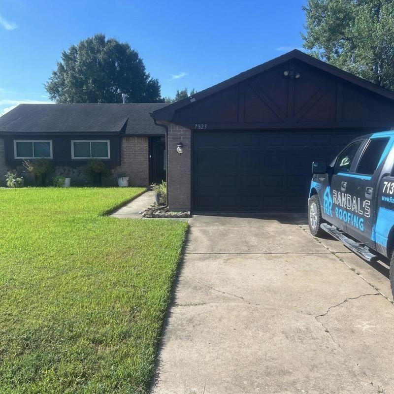 Asphalt shingle roof inspection with roofing truck nearby