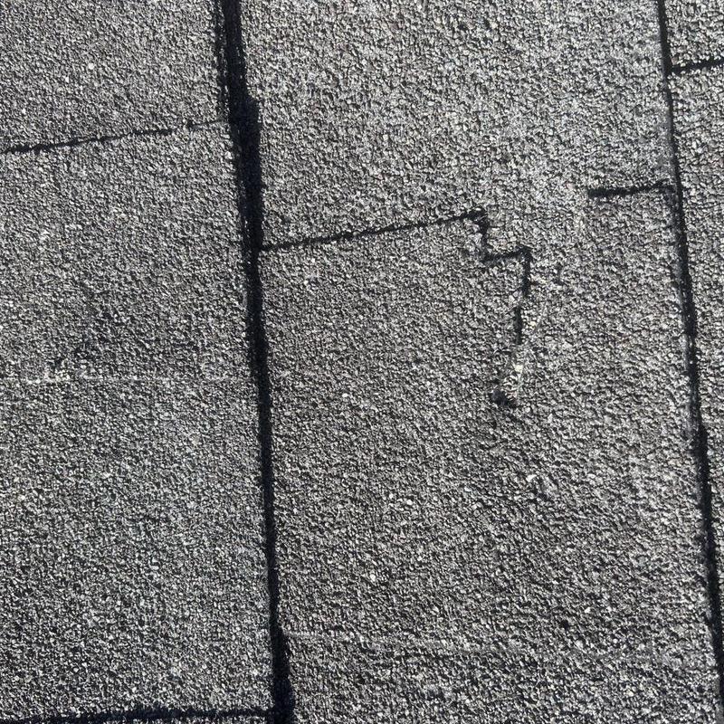Asphalt roof shingles with visible wear and damage