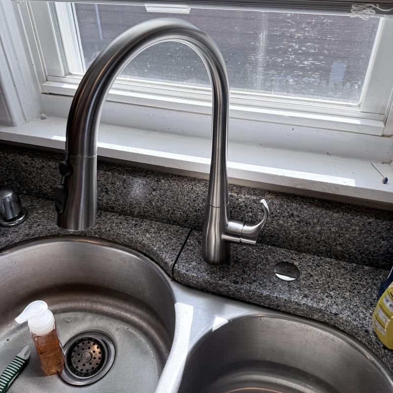 Kohler stainless steel kitchen faucet installed above sink