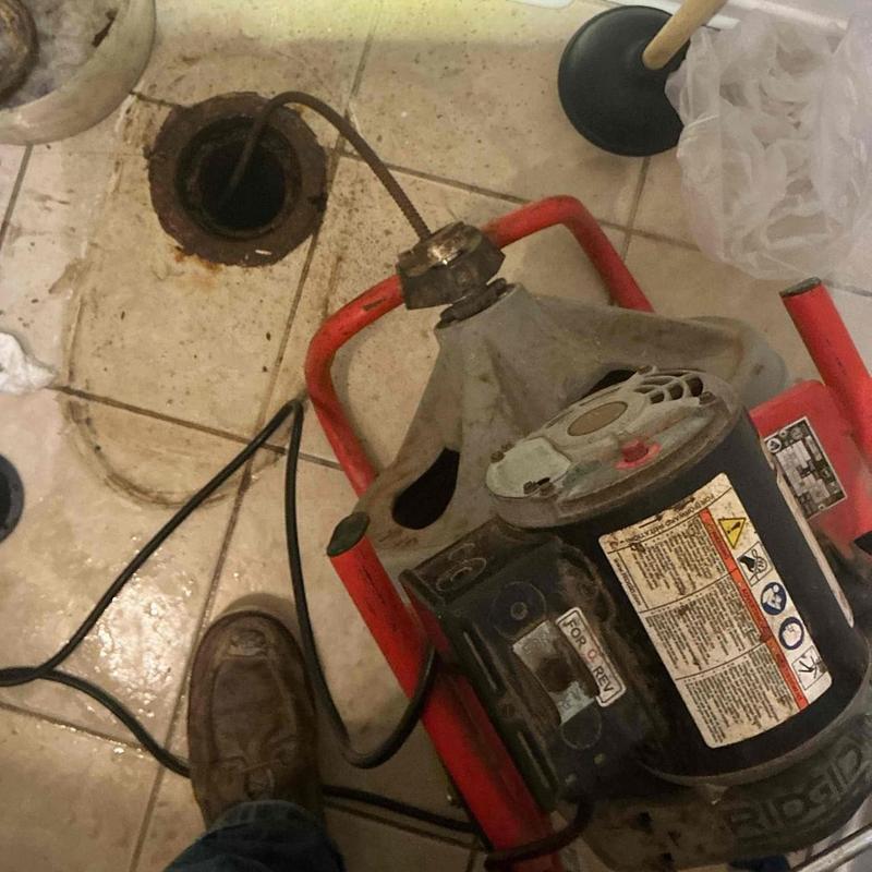 Toilet flange drain snake clearing sewer line blockage