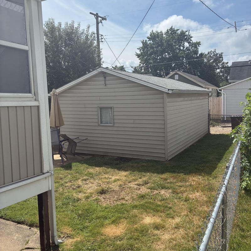 Garage roof and siding exterior view with tools nearby