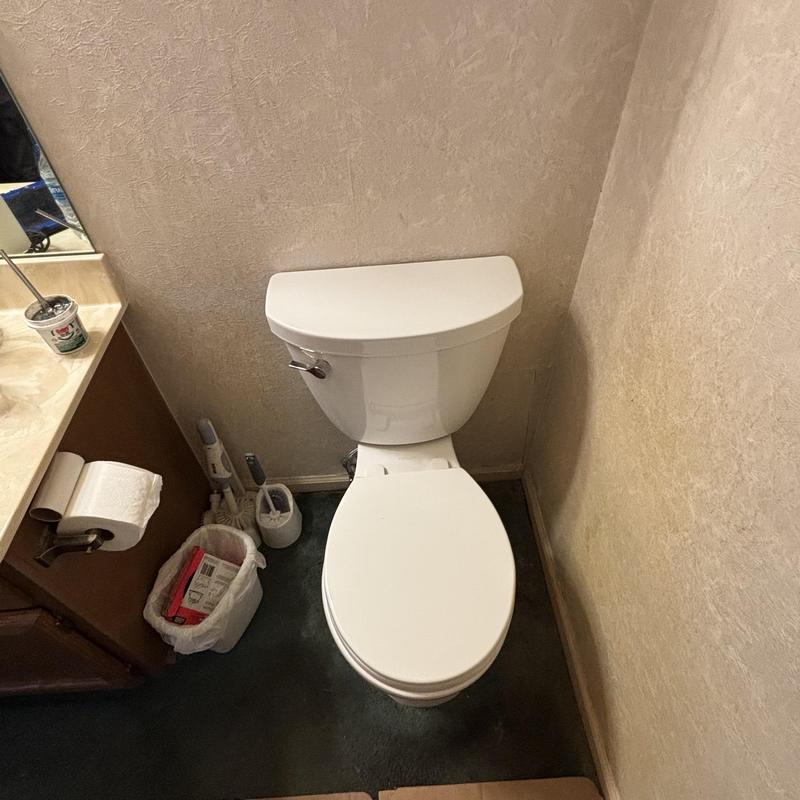 Toilet with closed lid in bathroom corner Toilet with closed lid in bathroom corner