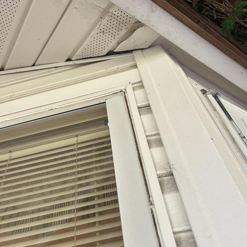 Soffit and siding with wind damage above window trim Soffit and siding with wind damage above window trim
