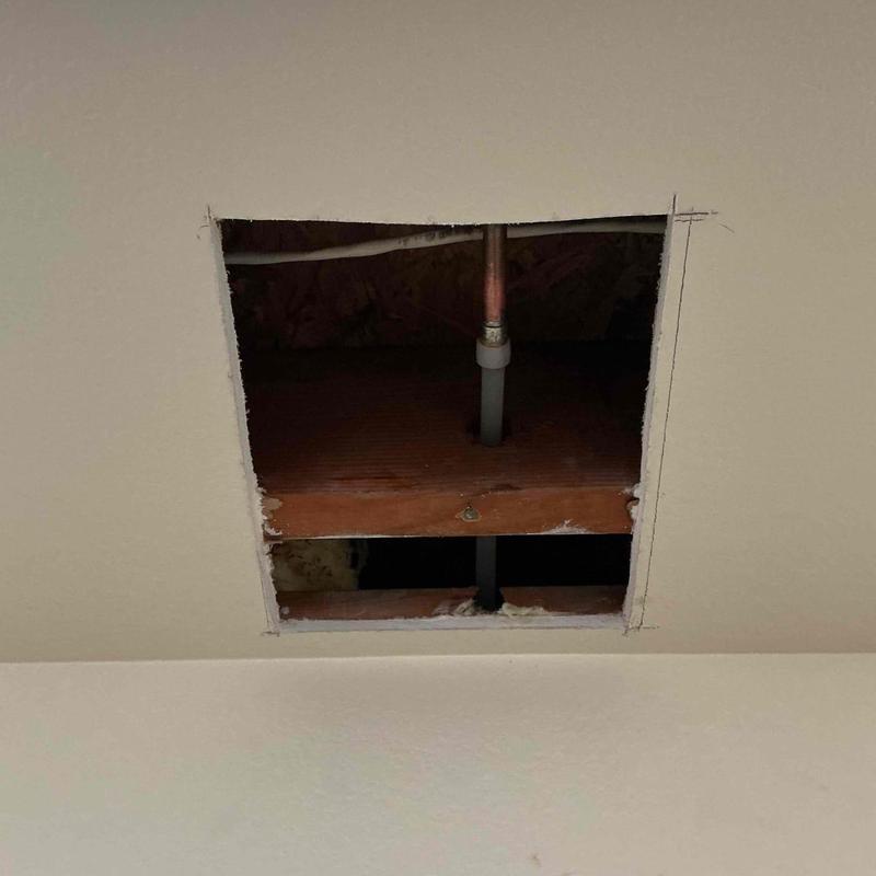 Copper piping section in ceiling cutout for repair Copper piping section in ceiling cutout for repair